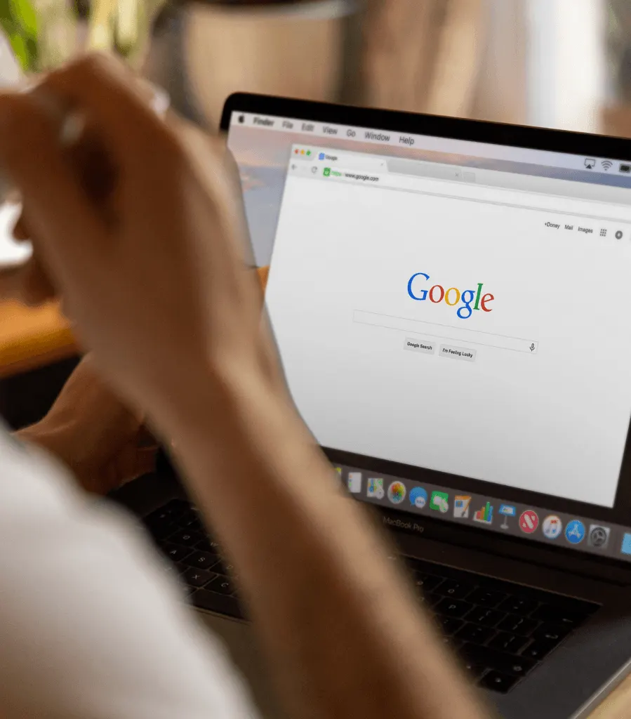 Person searching Google on a laptop
